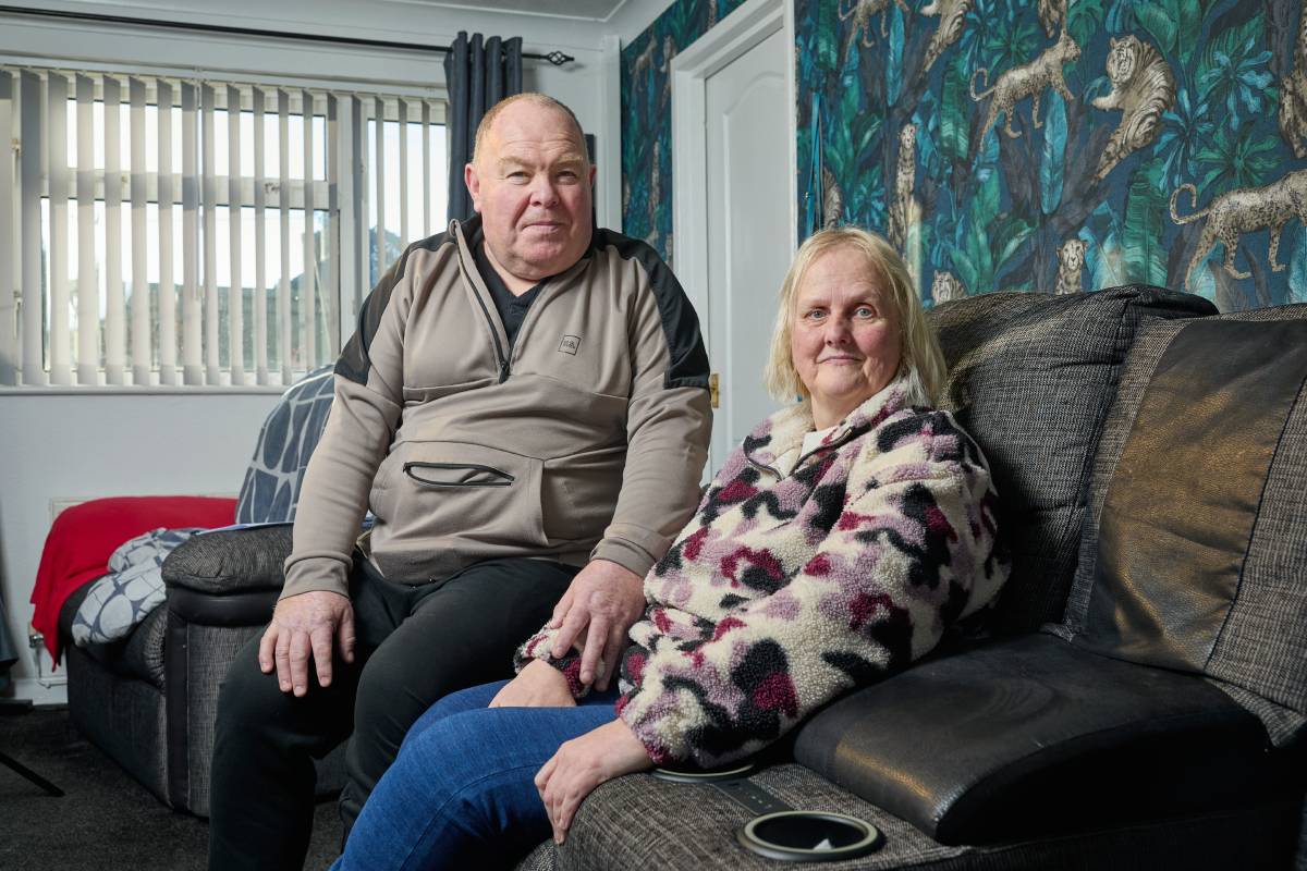 Person living with dementia and her husband sitting on sofa at home